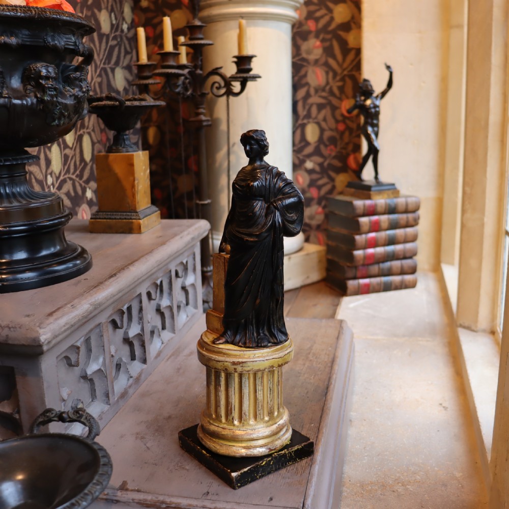 A dark ebonised carved wood figure of the classical goddess Fortuna set atop a gilded fluted column pedestal and square base. View II