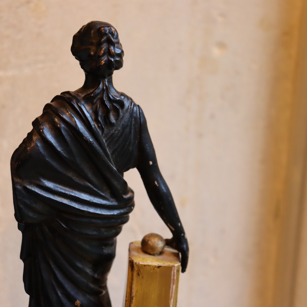 A dark ebonised carved wood figure of the classical goddess Fortuna set atop a gilded fluted column pedestal and square base. View IV