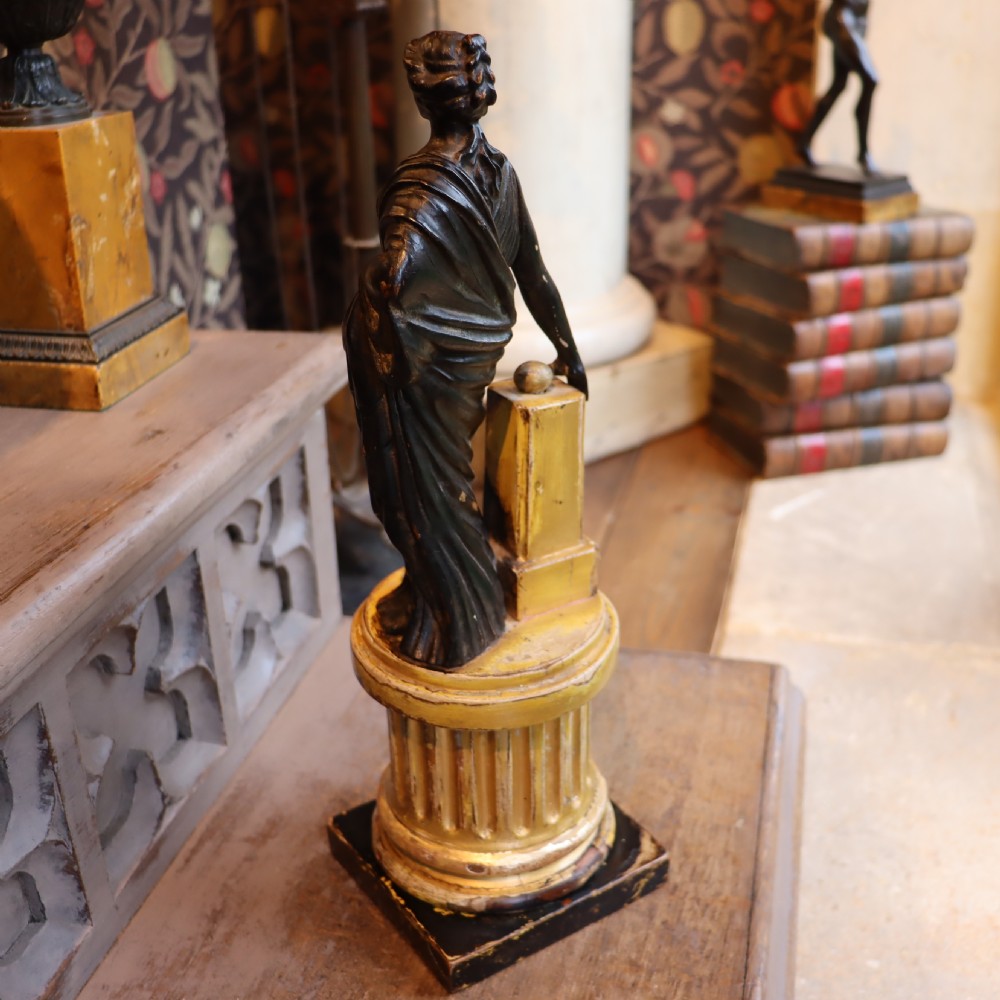 A dark ebonised carved wood figure of the classical goddess Fortuna set atop a gilded fluted column pedestal and square base. View VI