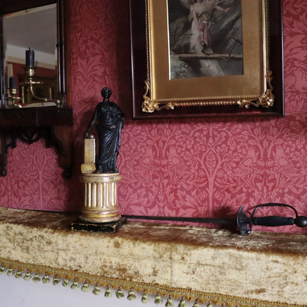 A dark ebonised carved wood figure of the classical goddess Fortuna set atop a gilded fluted column pedestal and square base. View VII