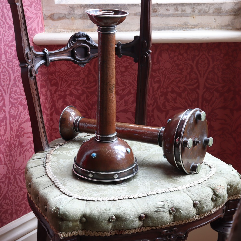 A pair of tall Arts and Crafts hammered copper candlesticks featuring domed bases inlaid with turquoise cabochons and silver detail. View III