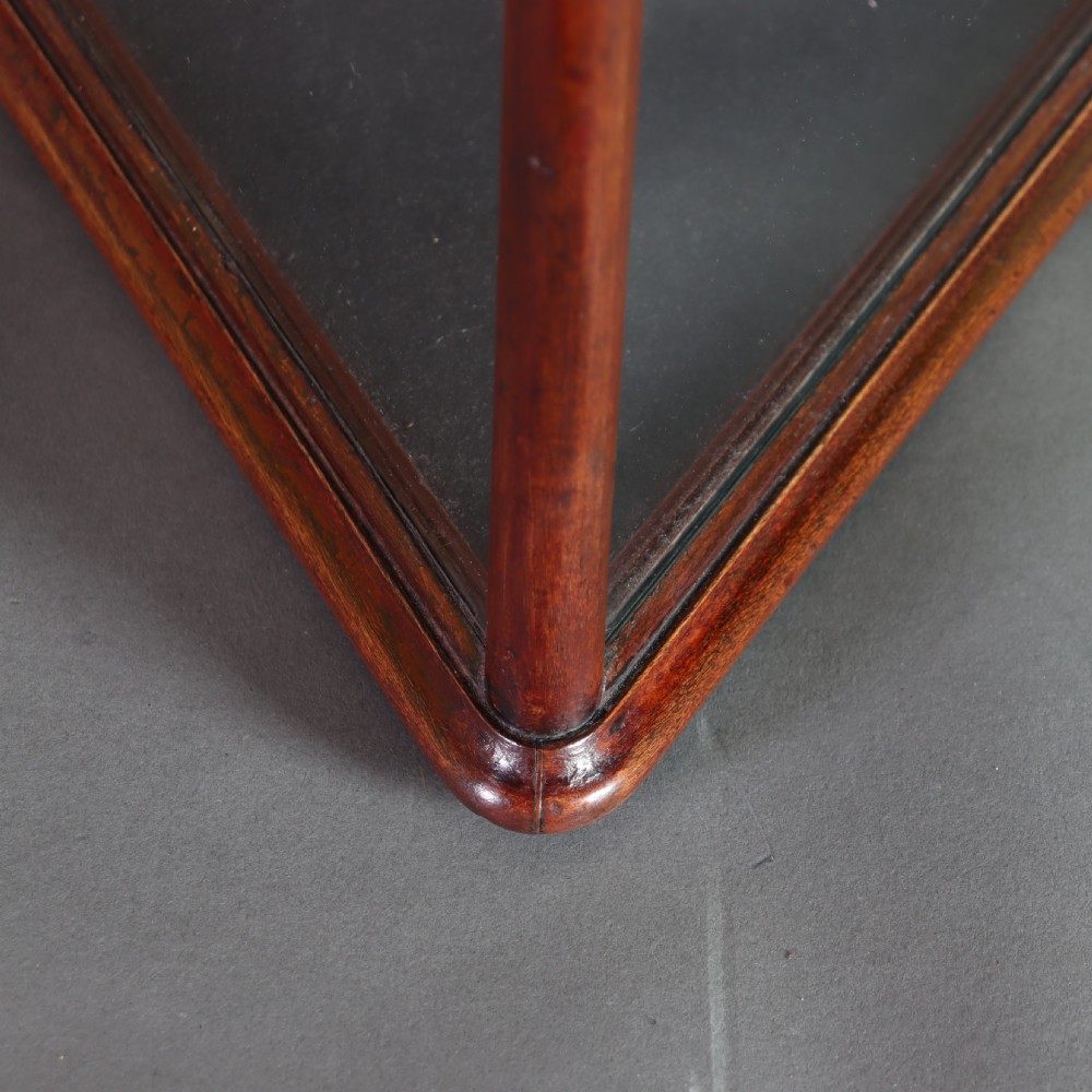A Victorian mahogany and glass corner display cabinet featuring three glass shelves and mirrored back doors. View VII