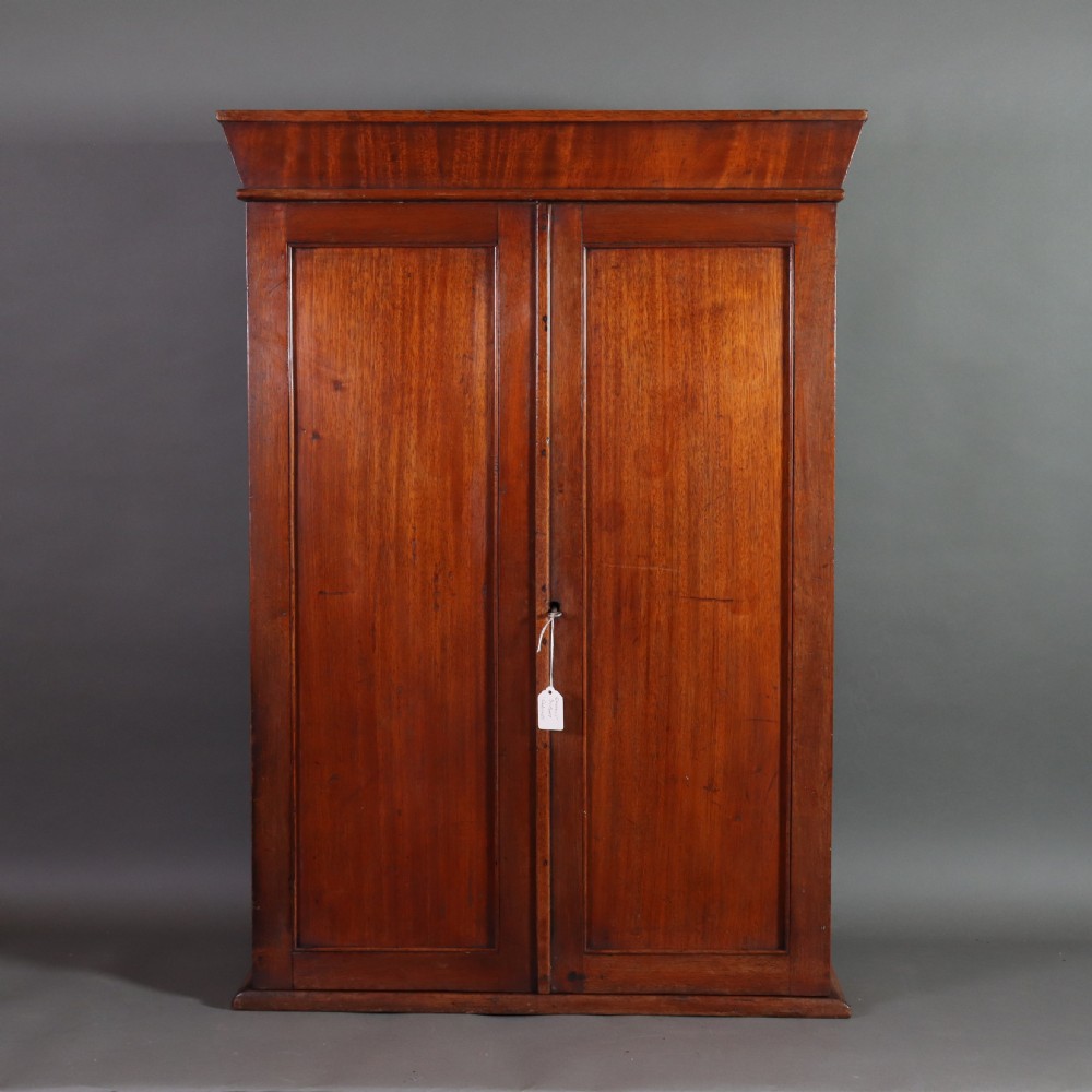 A Victorian mahogany pharmacy display cabinet featuring carved side columns, glass shelves, and gilded glass lettering reading Kemps Pharmacy Chemist and Opticians. View V