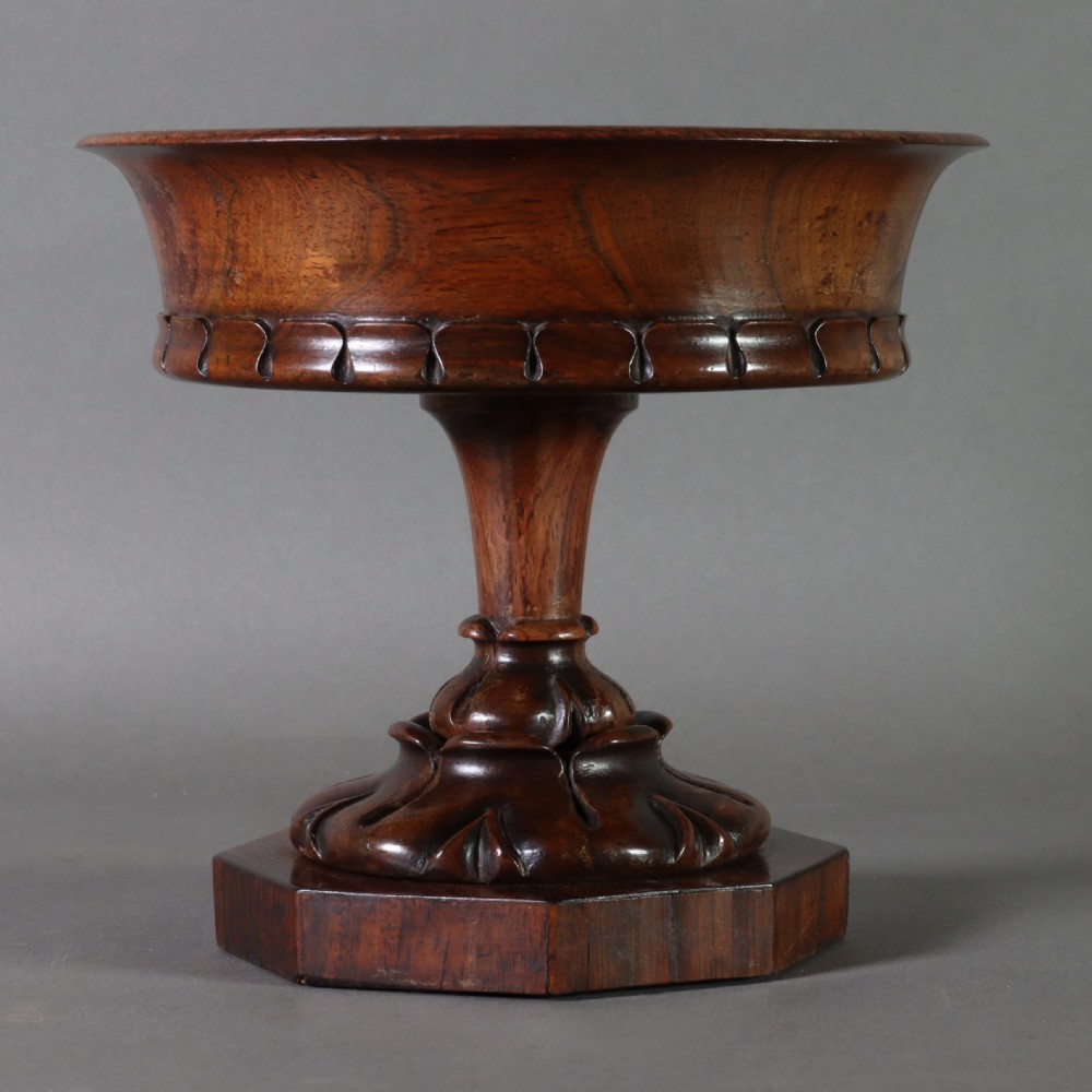 A dark rosewood tazza urn featuring a circular flared rim with an integrated brass liner, supported by a turned pedestal on an octagonal wooden base. View V