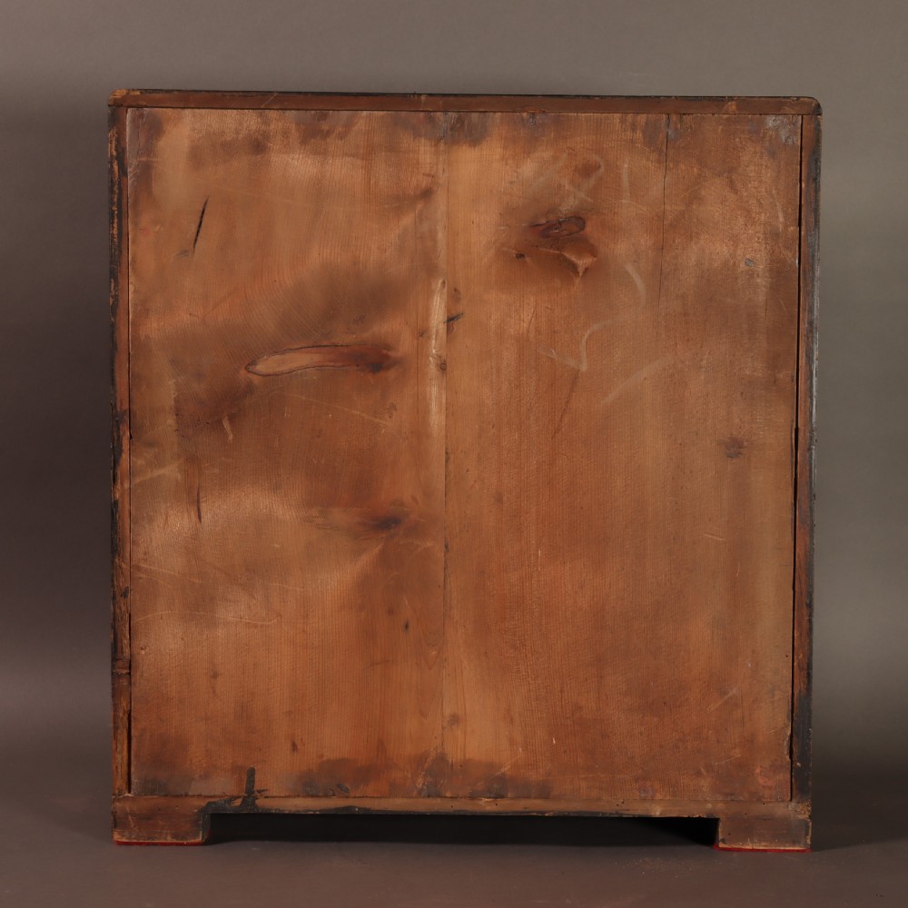 An early 20th-century cased taxidermy pet dog seated on a red fabric cushion against a painted sky background inside a glazed wooden case with gilt trim. View XI