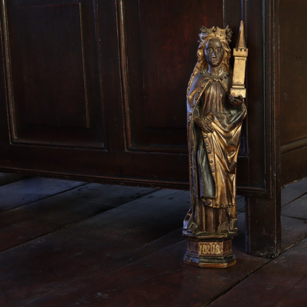 A 17th-century German carved polychrome and giltwood sculpture depicting Saint Barbara holding a tower, standing upon an inscribed plinth. View III