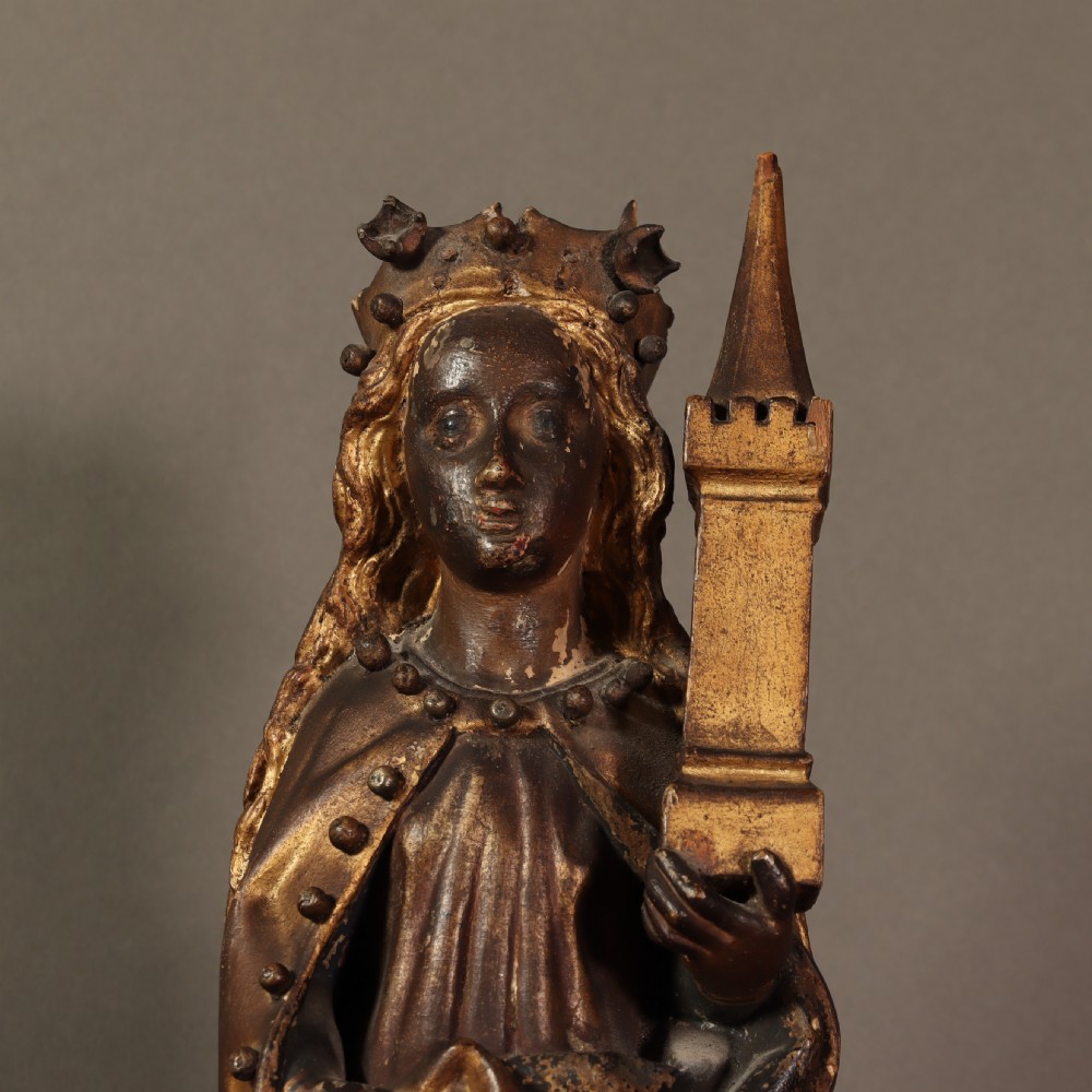 A 17th-century German carved polychrome and giltwood sculpture depicting Saint Barbara holding a tower, standing upon an inscribed plinth. View V