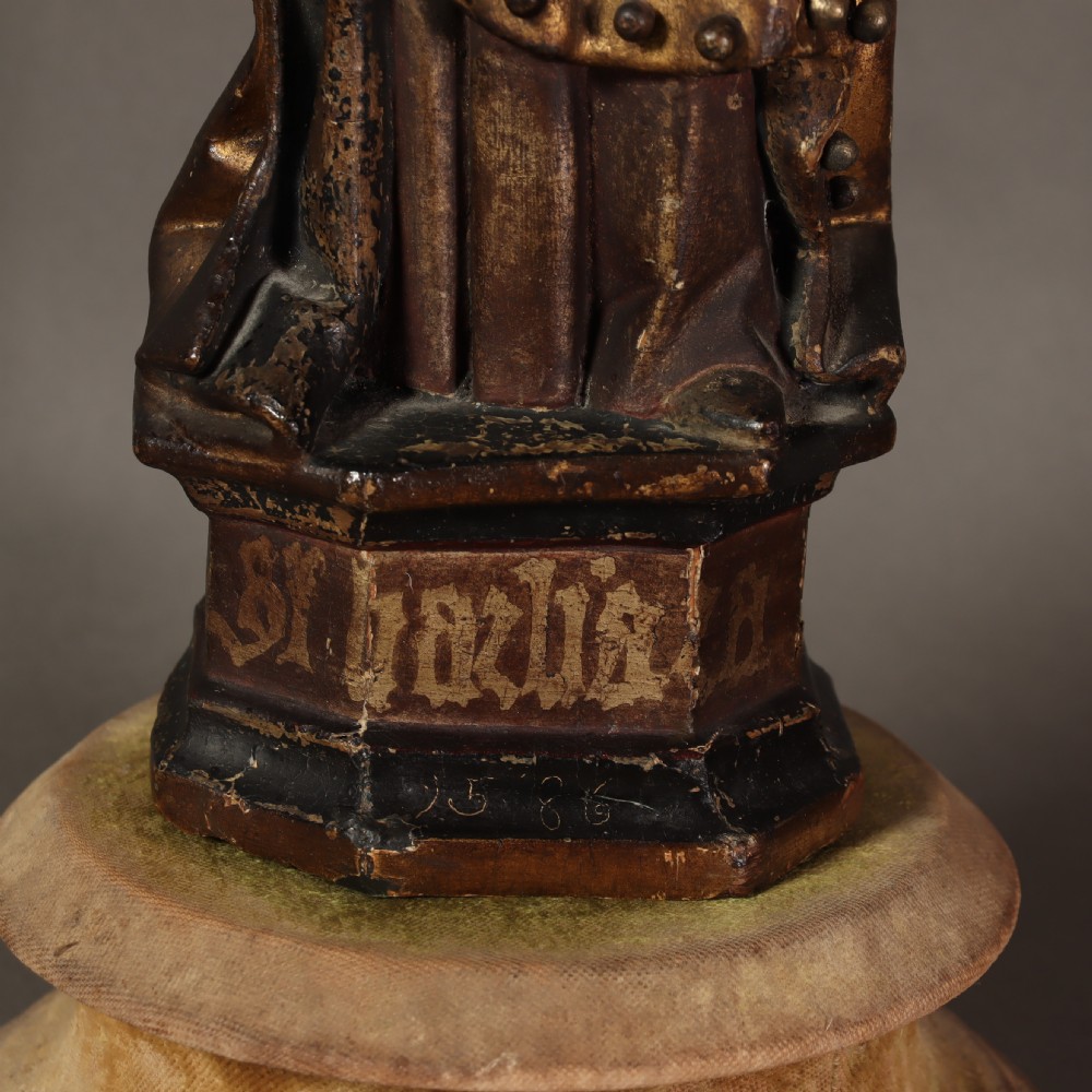 A 17th-century German carved polychrome and giltwood sculpture depicting Saint Barbara holding a tower, standing upon an inscribed plinth. View VI