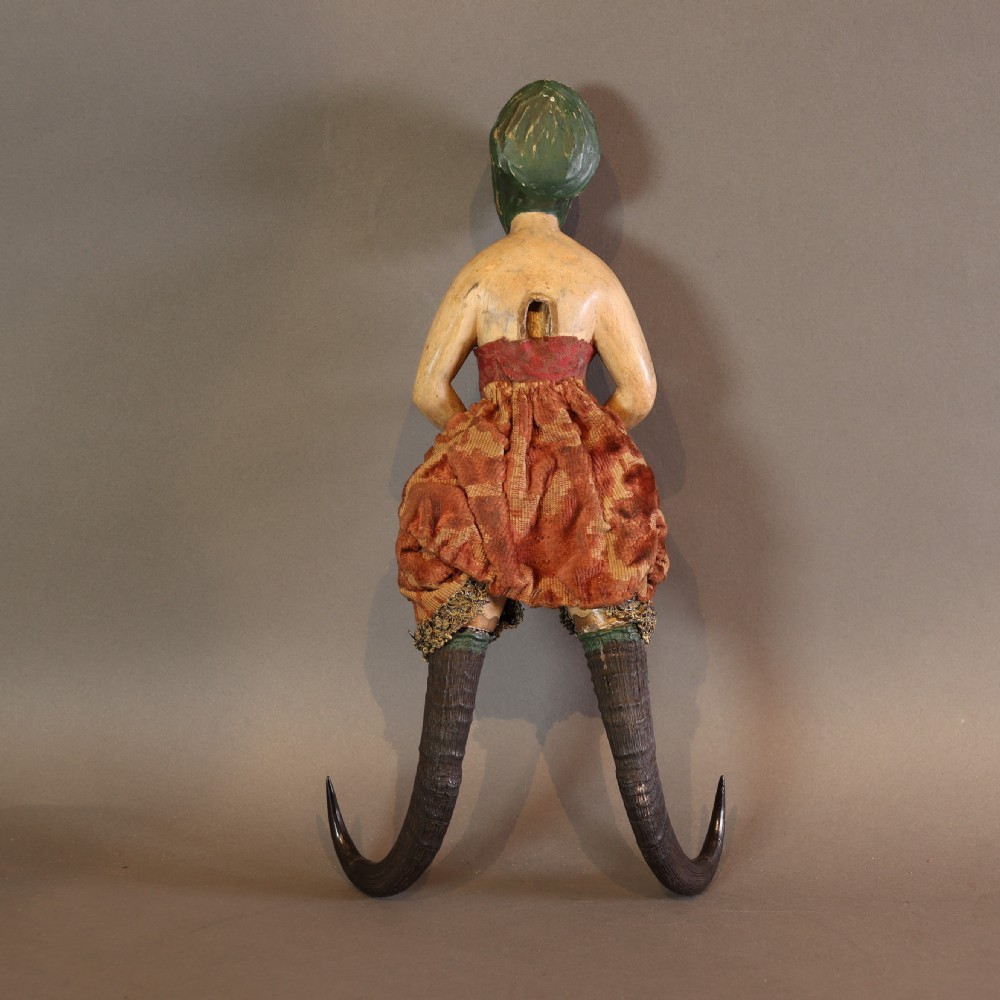 A 19th-century carved wood and horn wall hook featuring a polychrome figure of a female torso above curved dark horns forming the hooks. View IV