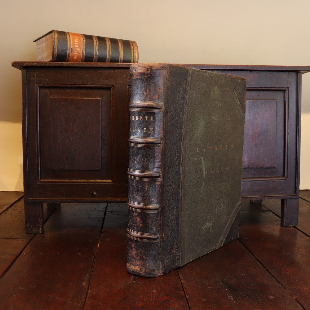 An upright dark brown leather-bound box designed to resemble a large book, embossed with the text Lambeth Palace on the spine and front cover. View II