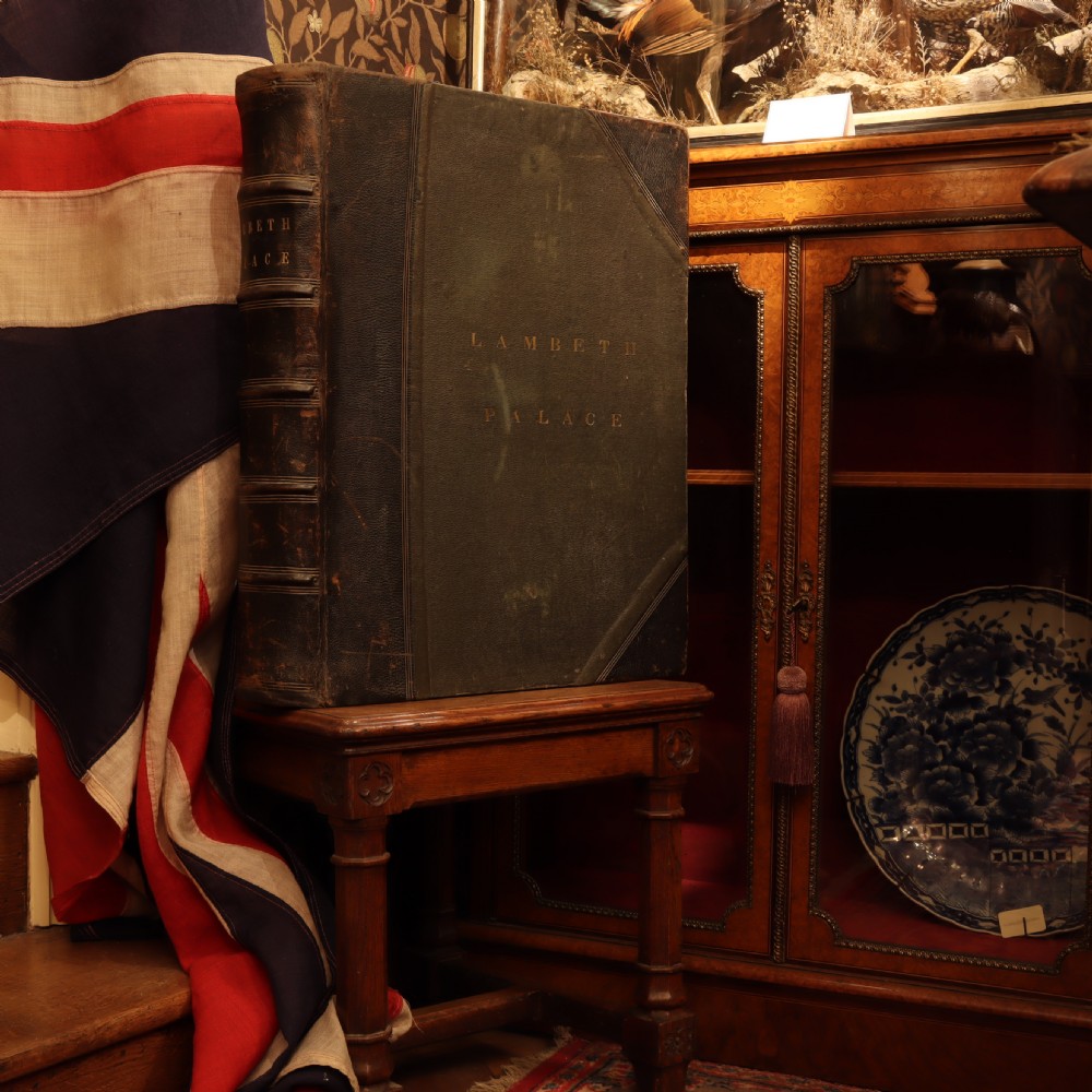 An upright dark brown leather-bound box designed to resemble a large book, embossed with the text Lambeth Palace on the spine and front cover. View III