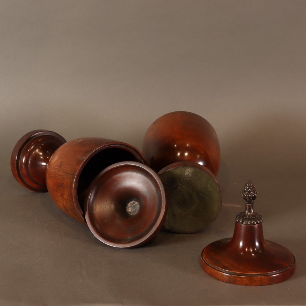 Treen – Pair of Neo Classical mid 19th Century mahogany lidded urns with brass pineapple inspired finials.  View VIII