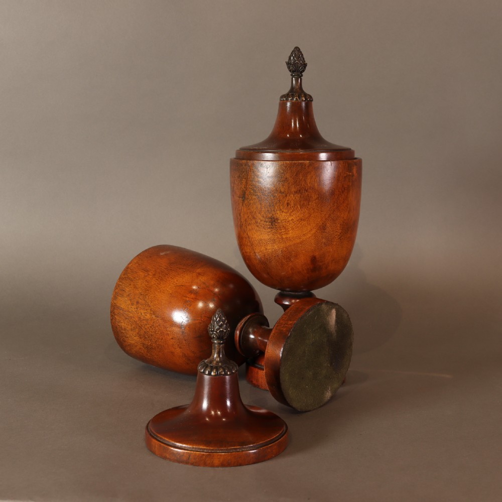 Treen – Pair of Neo Classical mid 19th Century mahogany lidded urns with brass pineapple inspired finials.  View IX