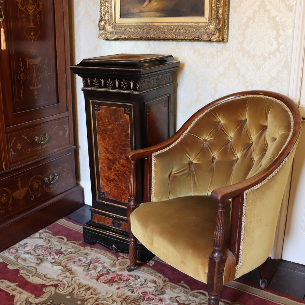 An ebonised Victorian Aesthetic Movement display pedestal featuring inset burr walnut panels, gilt incised frieze detailing, and a moulded square top. View III