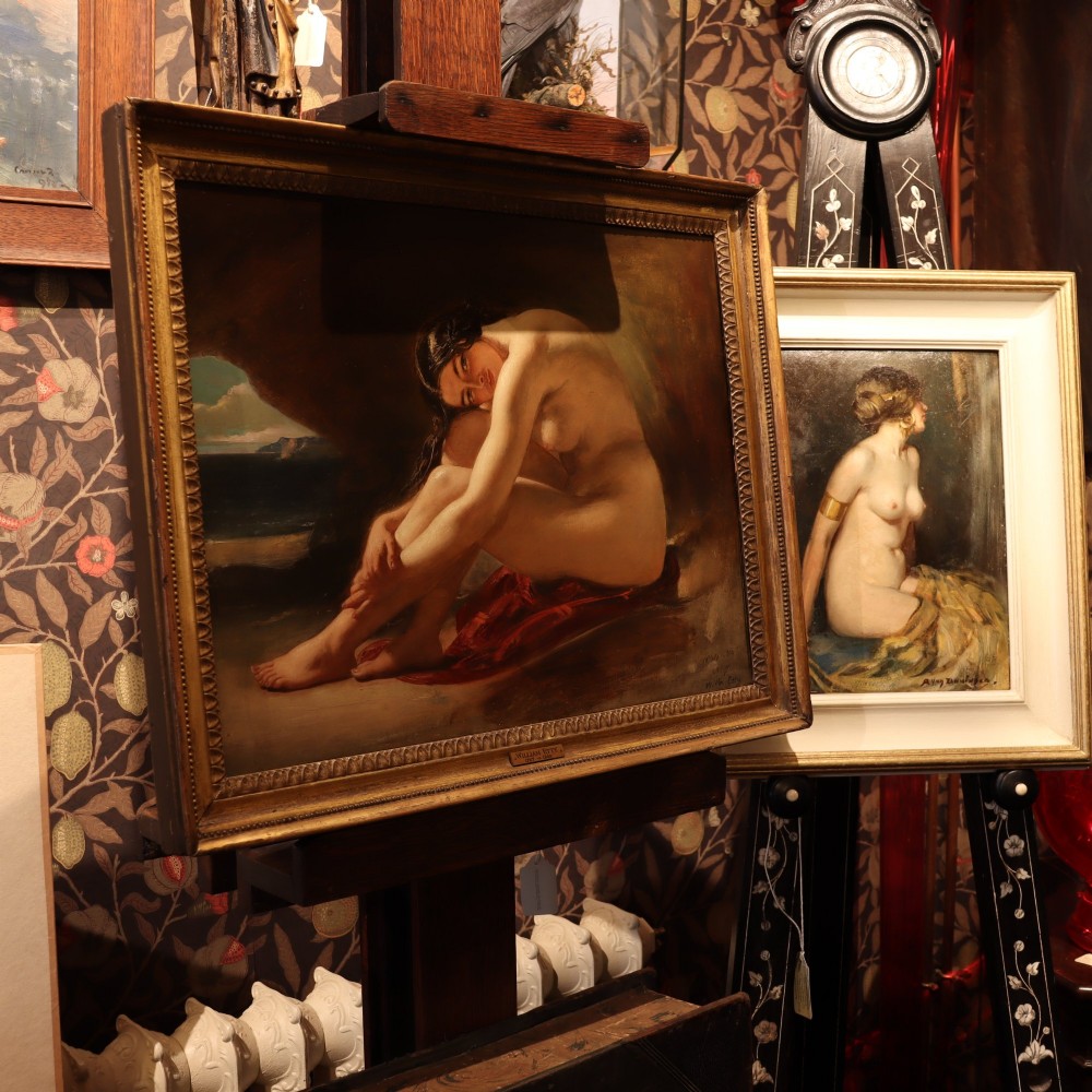 An antique oil painting on wood panel depicting a seated female nude inside a dark cave facing a seascape, set within a gilded molded frame. View VIII