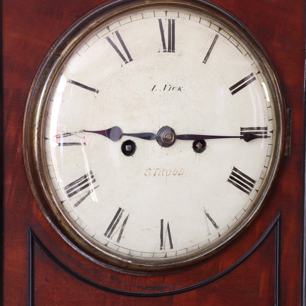 A George IV mahogany bracket clock featuring ebony inlaid lines, brass ball feet, side carrying handles, and a circular white dial signed by L. Vick of Stroud. View IV