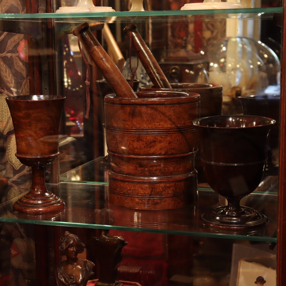 A turned dark brown lignum vitae wooden mortar with horizontal ridge mouldings shown with a matching turned pestle. View II