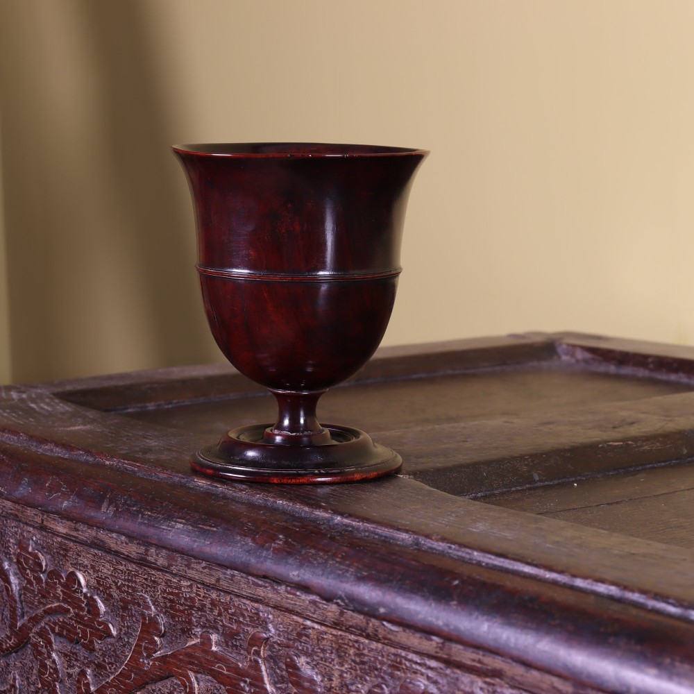 A dark brown lathe-turned lignum vitae pedestal goblet with a flared rim and circular foot. View II