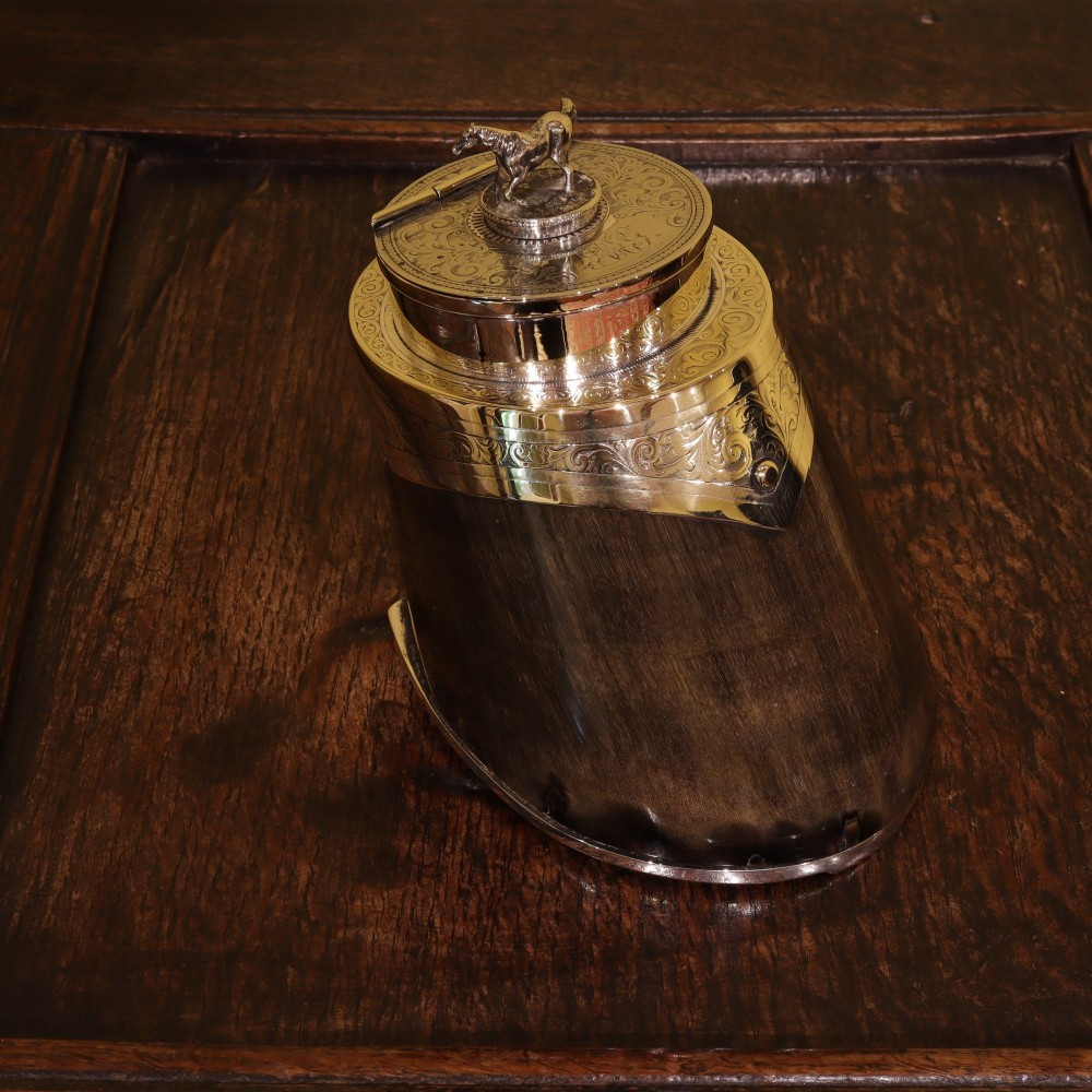 A Victorian desk tidy crafted from a preserved horse hoof with engraved silver mounts and a lid featuring a sculpted horse figurine. View II