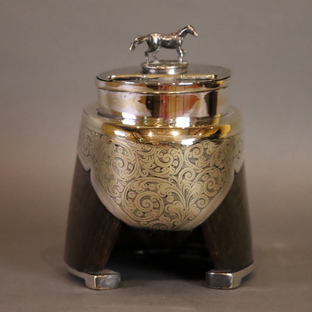 A Victorian desk tidy crafted from a preserved horse hoof with engraved silver mounts and a lid featuring a sculpted horse figurine. View VI