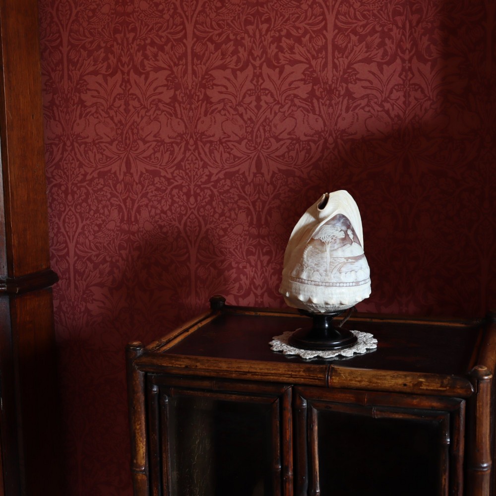 An illuminated 19th-century conch shell carved in relief with a scene depicting Mount Vesuvius, mounted on a turned ebonised wood base. View II