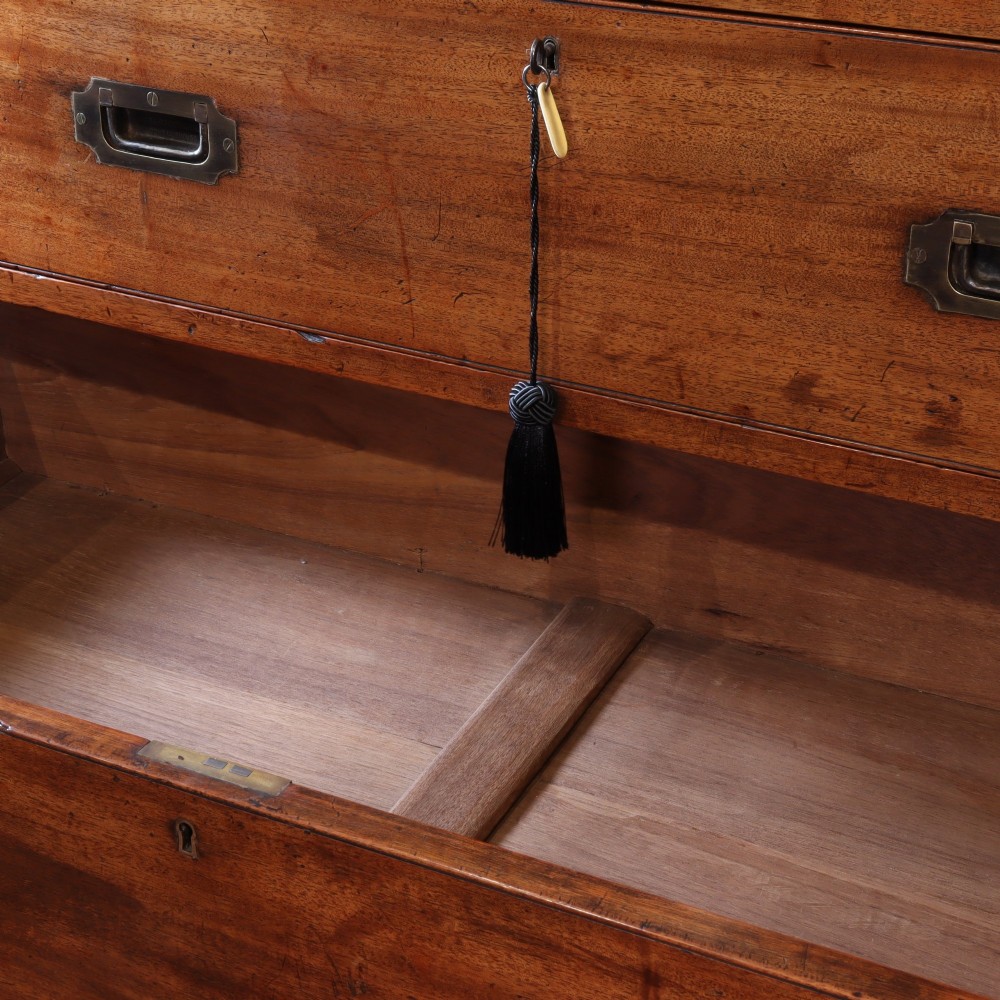 A Victorian mahogany two-part military campaign chest of drawers featuring recessed brass handles, corner brackets, side carrying handles, and short turned feet. View V