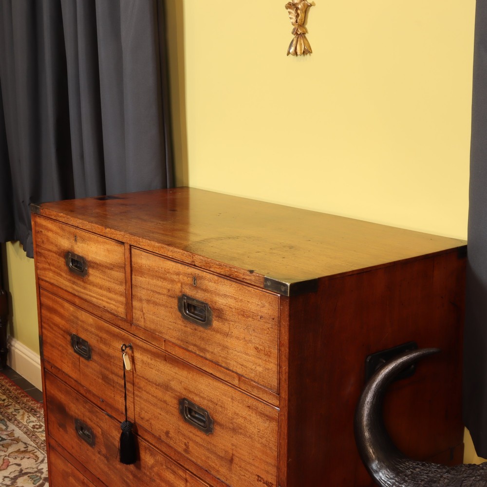 A Victorian mahogany two-part military campaign chest of drawers featuring recessed brass handles, corner brackets, side carrying handles, and short turned feet. View VI