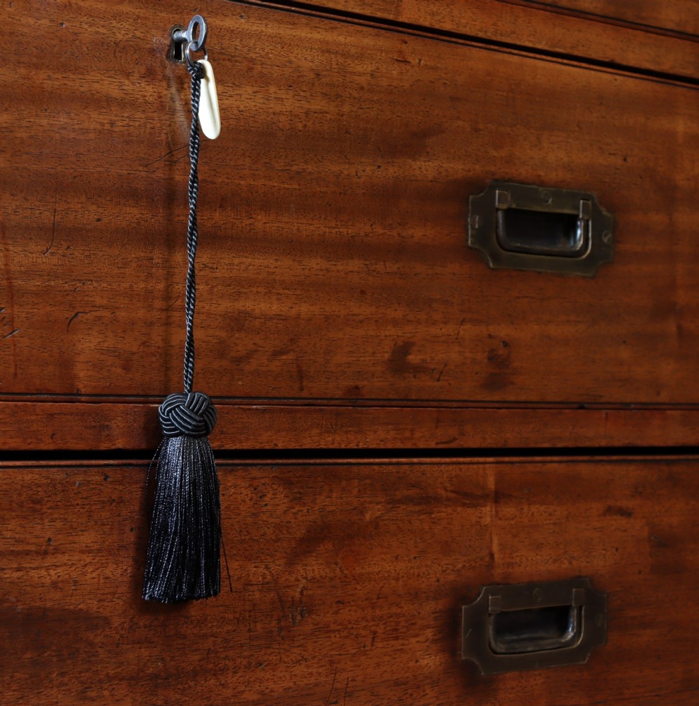 A Victorian mahogany two-part military campaign chest of drawers featuring recessed brass handles, corner brackets, side carrying handles, and short turned feet. View VII