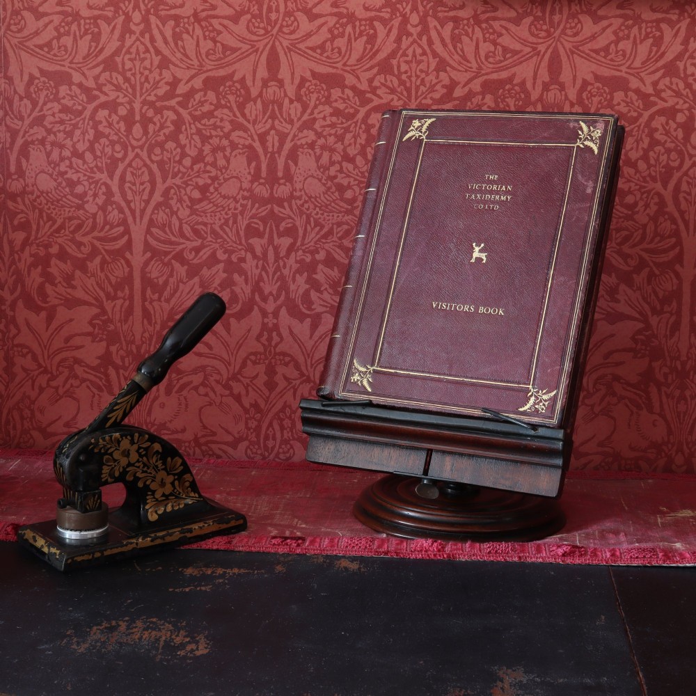 A 19th-century dark mahogany desktop reading stand featuring an upright wooden backplate, metal page retainers, and a moulded circular swivel base. View IV