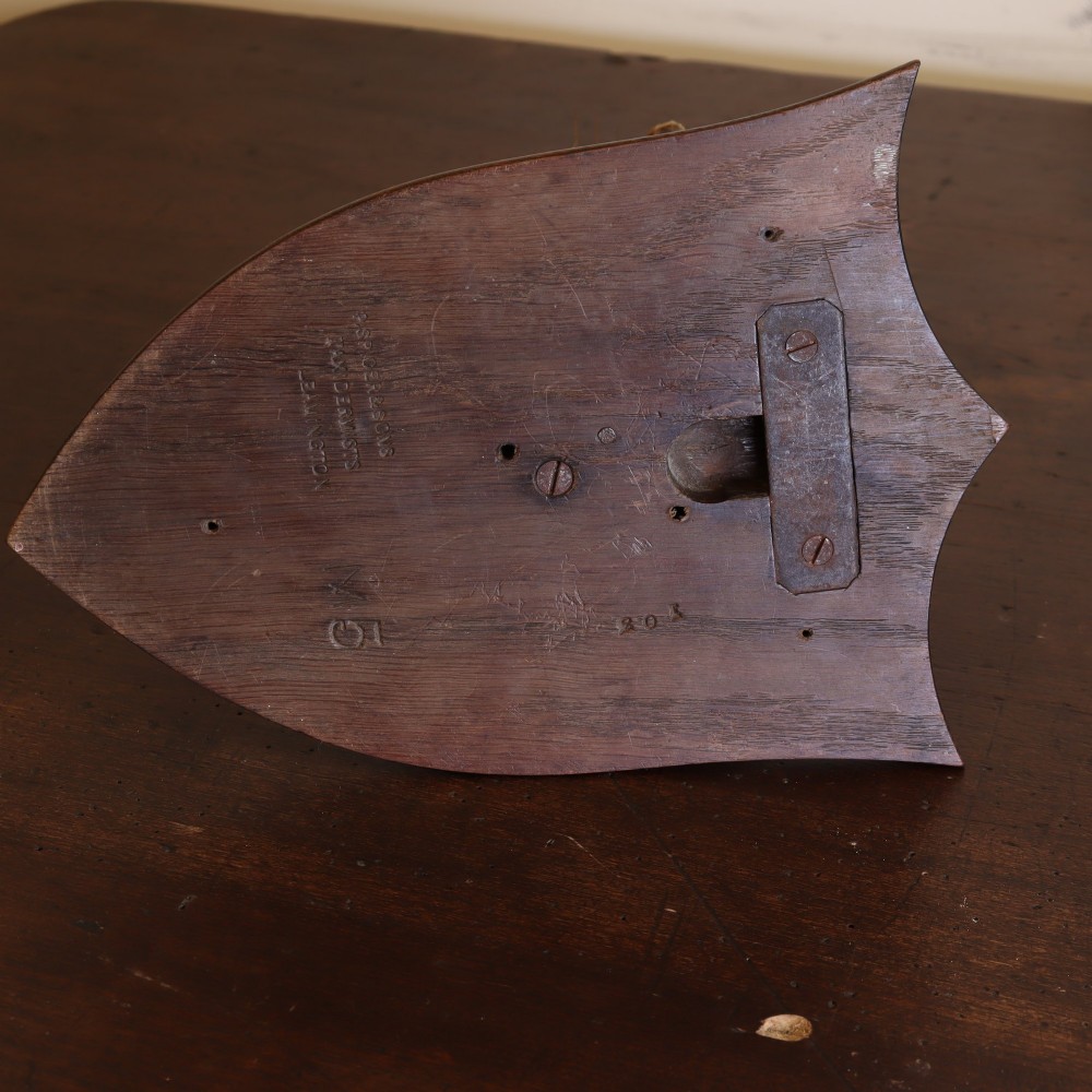 An early 20th-century taxidermy otter mask mounted on a dark wooden shield-shaped wall plaque. View III