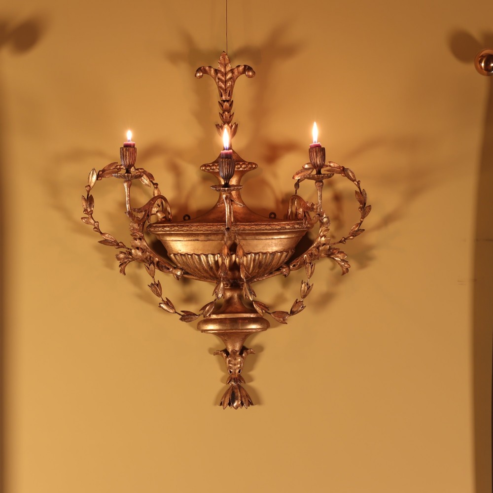 A George III style carved giltwood three-branch wall sconce featuring a central fluted urn motif flanked by scrolling foliate arms. View III