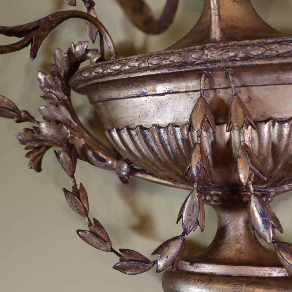 A George III style carved giltwood three-branch wall sconce featuring a central fluted urn motif flanked by scrolling foliate arms. View V