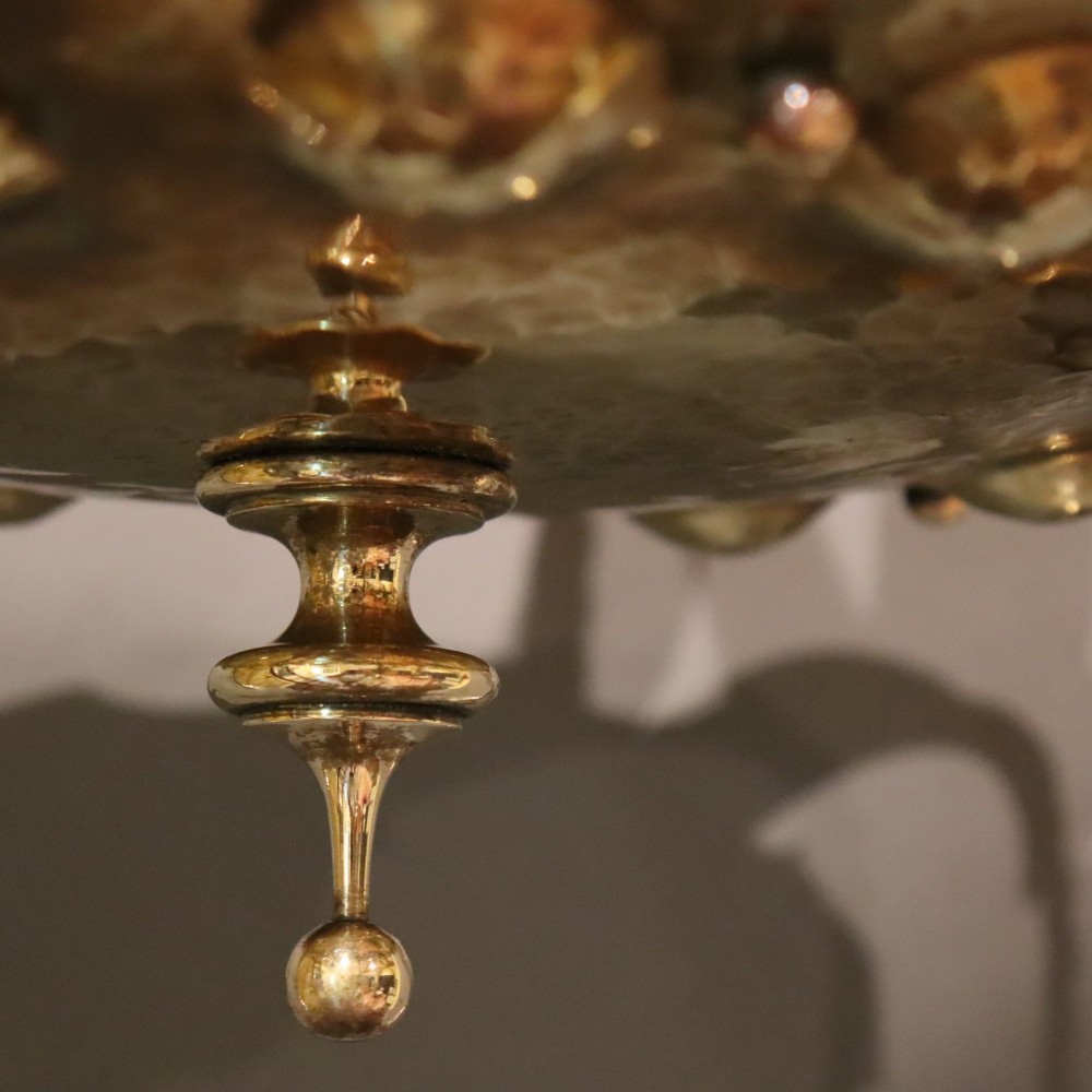 An antique Arts and Crafts brass ceiling fixture featuring a central hand-hammered canopy and three suspended drop pendant lights with frosted bell glass shades. View VII