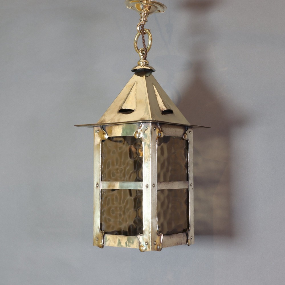 An Arts and Crafts style brass hanging lantern featuring amber textured glass panes, a riveted square body, a pyramidal top hood, and a ceiling chain suspension. View II