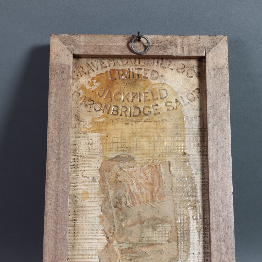 A rectangular moulded relief ceramic tile depicting an allegorical maiden with cherubs and birds, finished in an amber translucent glaze and set in a simple dark wooden frame. View III