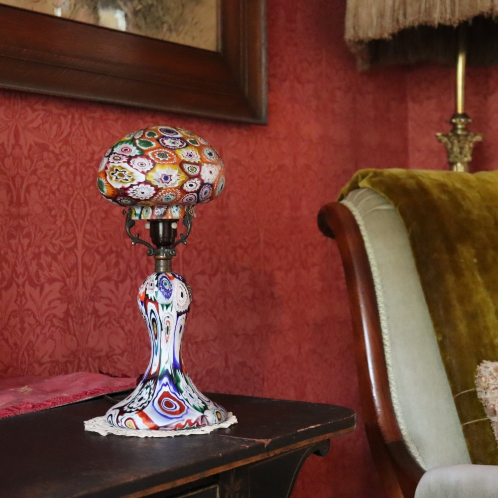 An Italian Art Deco millefiori glass table lamp featuring a colourful patterned mushroom shade and matching flared stem base with brass fittings.