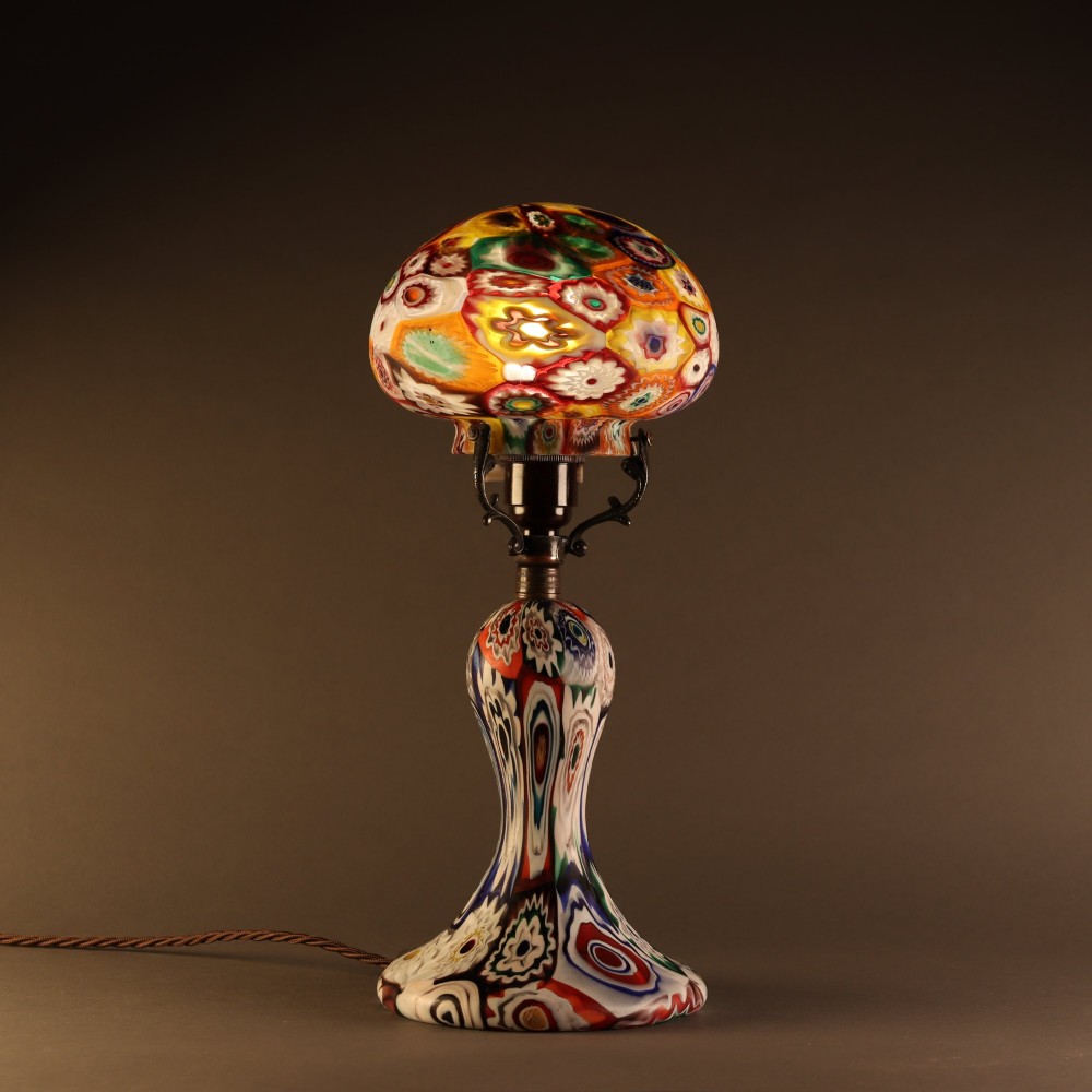 An Italian Art Deco millefiori glass table lamp featuring a colourful patterned mushroom shade and matching flared stem base with brass fittings. View V