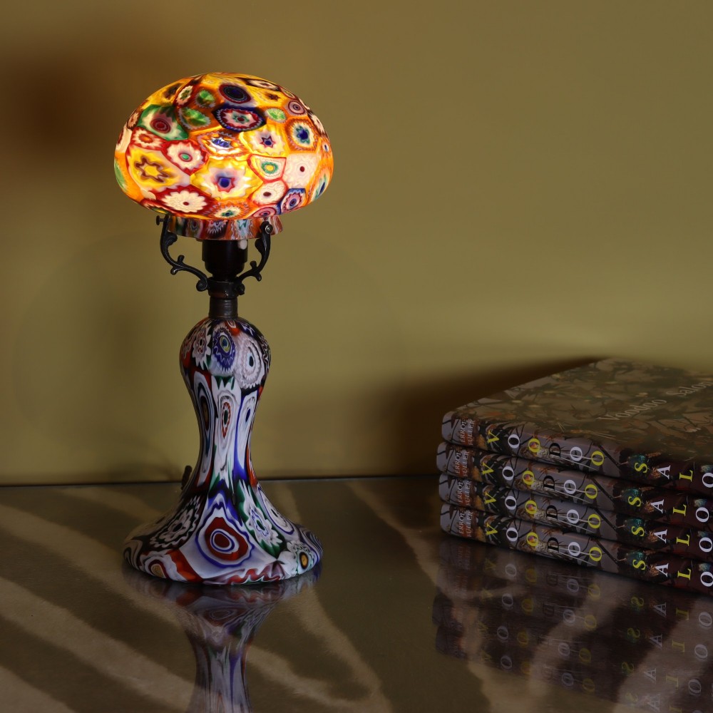 An Italian Art Deco millefiori glass table lamp featuring a colourful patterned mushroom shade and matching flared stem base with brass fittings. View VI