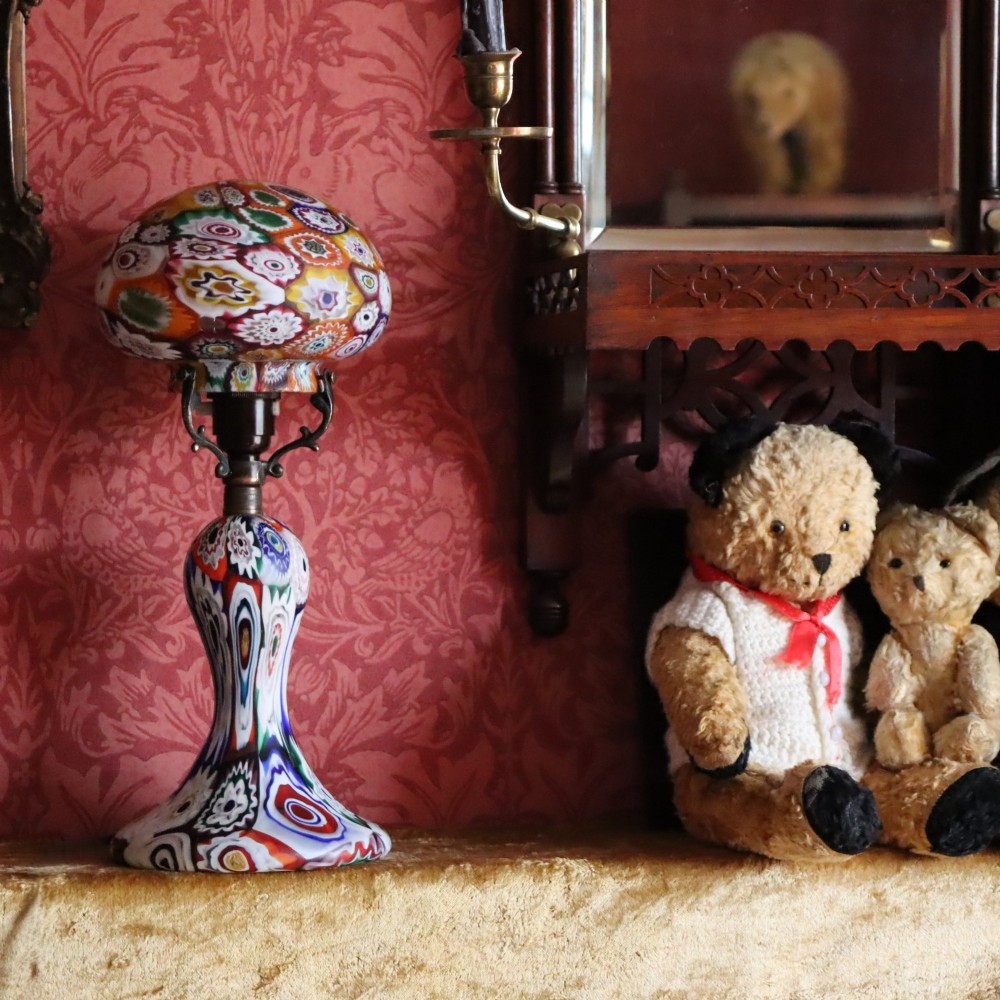 An Italian Art Deco millefiori glass table lamp featuring a colourful patterned mushroom shade and matching flared stem base with brass fittings. View VII