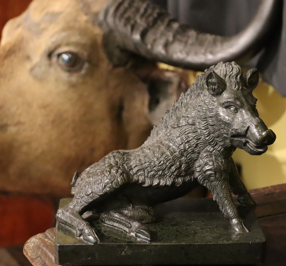 A late nineteenth-century Italian Grand Tour sculpture of a seated wild boar carved from dark green serpentine marble set on a rectangular stone plinth. View V