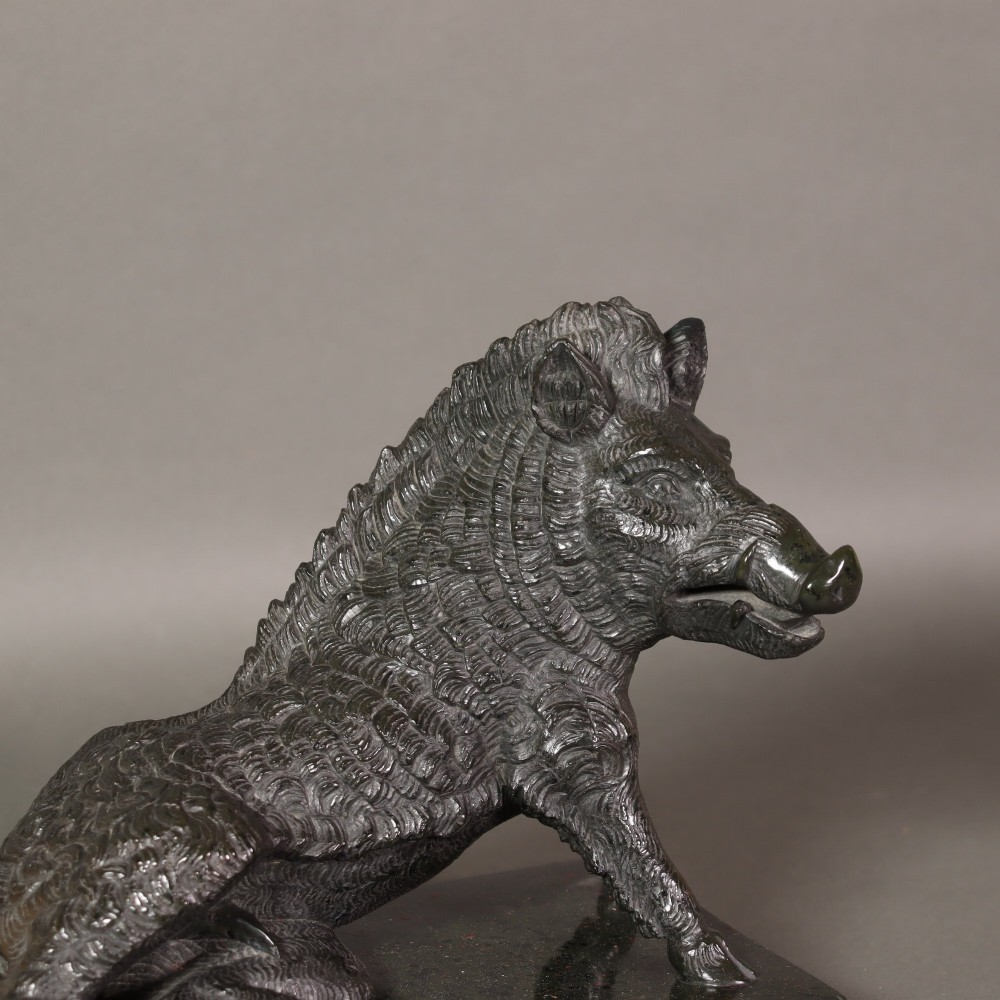 A late nineteenth-century Italian Grand Tour sculpture of a seated wild boar carved from dark green serpentine marble set on a rectangular stone plinth. View VII