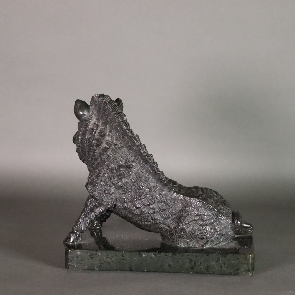 A late nineteenth-century Italian Grand Tour sculpture of a seated wild boar carved from dark green serpentine marble set on a rectangular stone plinth. View VIII