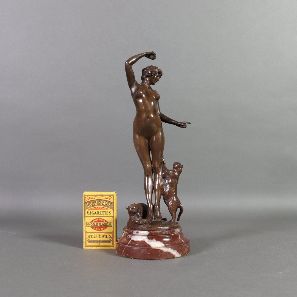 An Art Nouveau patinated bronze sculpture of a standing female figure with two cats mounted on a red marble base. View IV