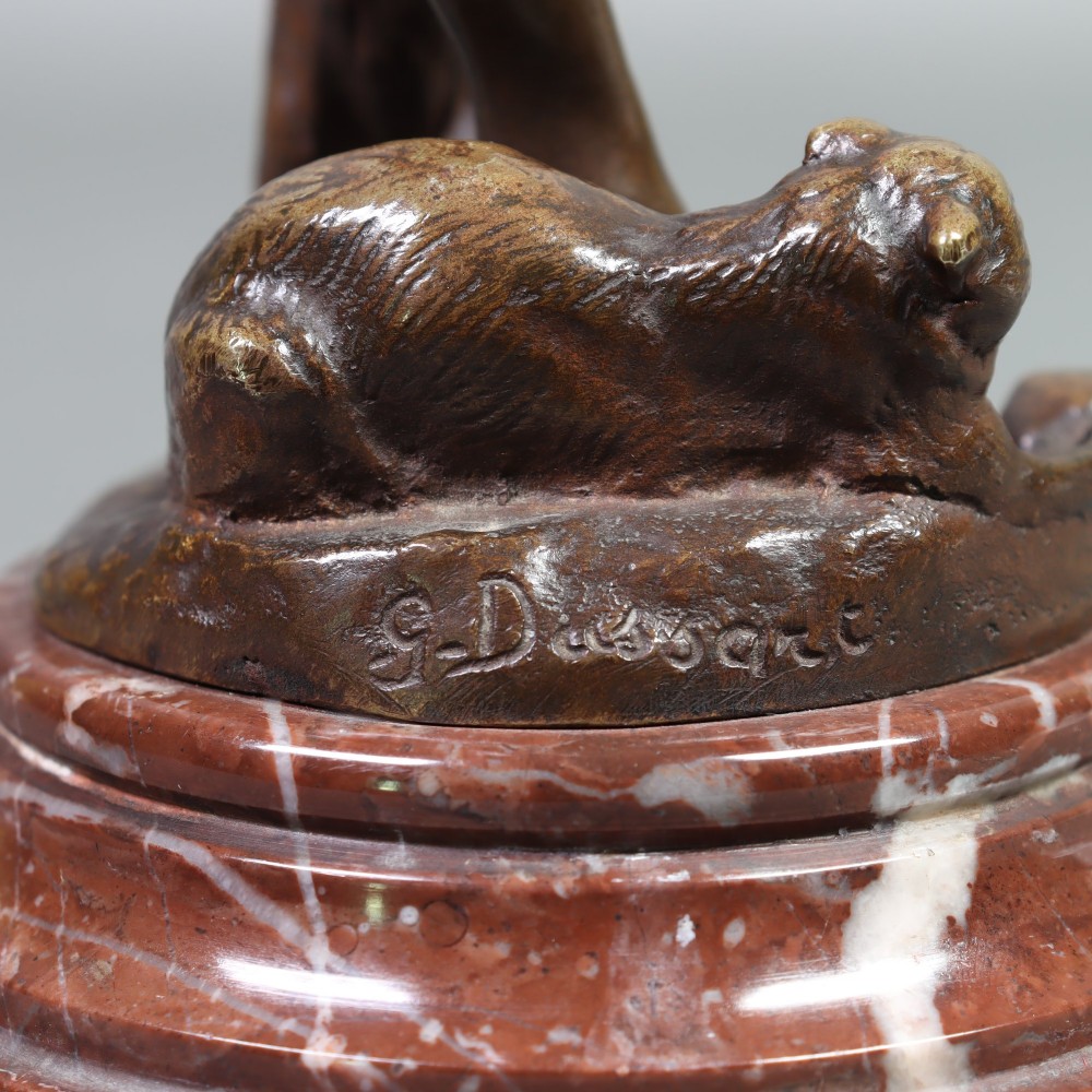 An Art Nouveau patinated bronze sculpture of a standing female figure with two cats mounted on a red marble base. View V