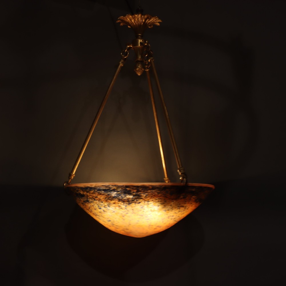 An Art Deco glass plafonnier featuring a warm mottled orange and dark blue bowl shade suspended by three gilt metal rods and a decorative ceiling rose. View IV
