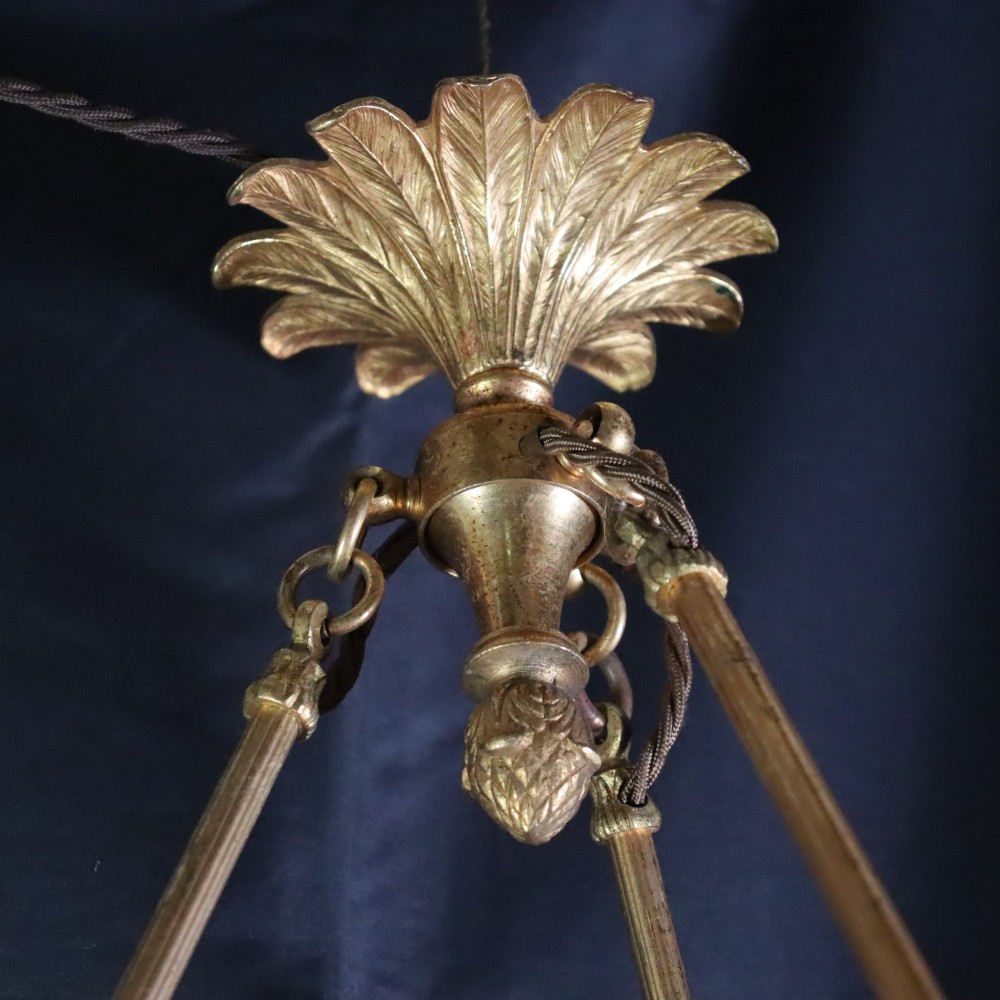 An Art Deco glass plafonnier featuring a warm mottled orange and dark blue bowl shade suspended by three gilt metal rods and a decorative ceiling rose. View V