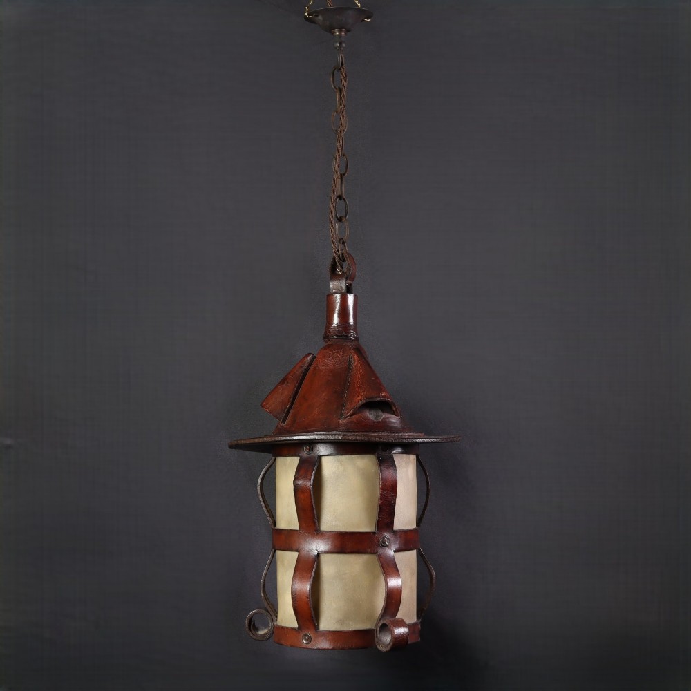 An Arts and Crafts hanging lantern featuring a hand-stitched dark brown leather framework surrounding illuminated vellum panels with scrolled metal feet. View III