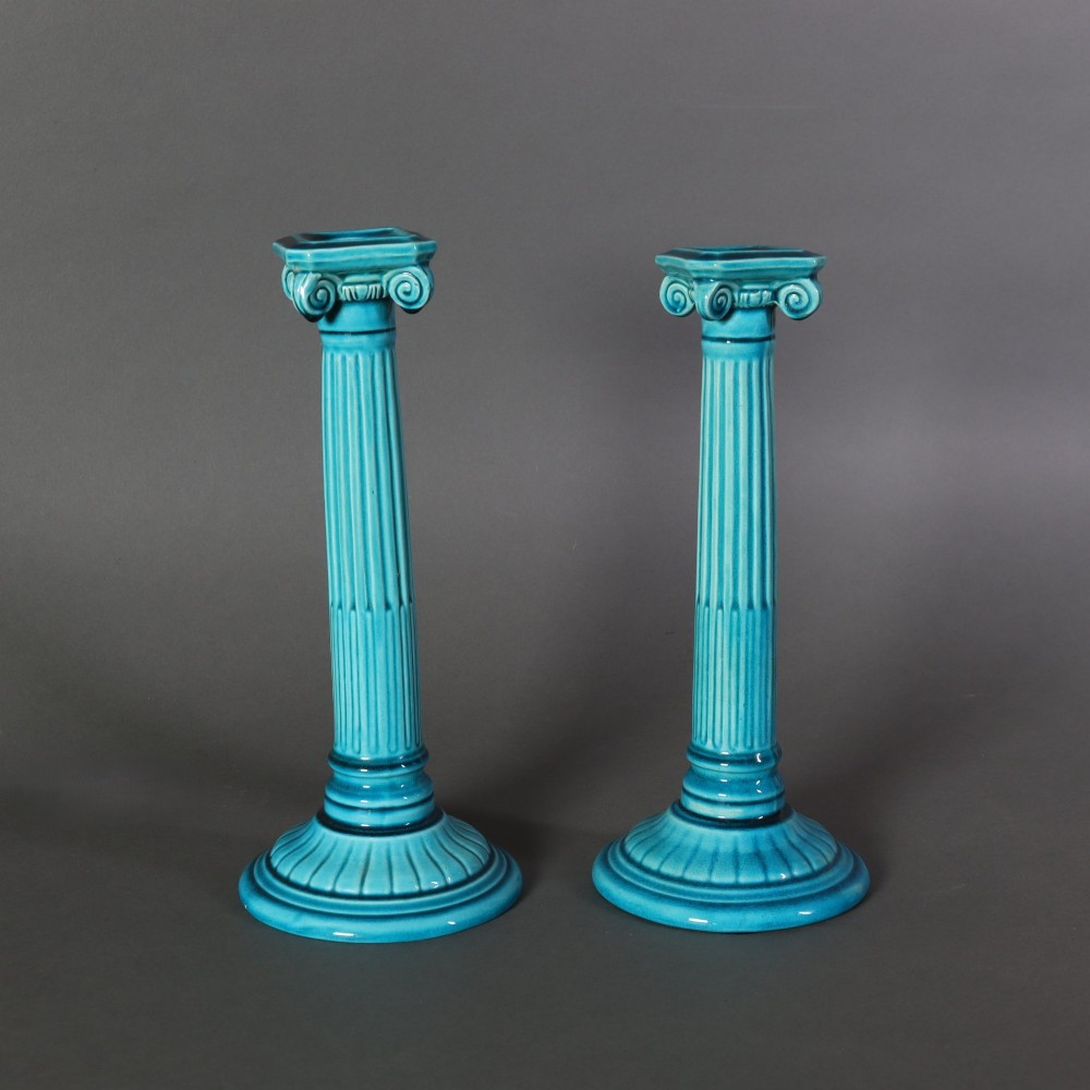A matched pair of late 19th-century turquoise glazed ceramic candlesticks in the shape of classical fluted Ionic columns.