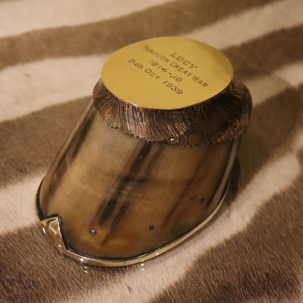 A preserved horse hoof mounted with an engraved brass top plate detailing military service dates and fitted with a polished brass rim around the base.