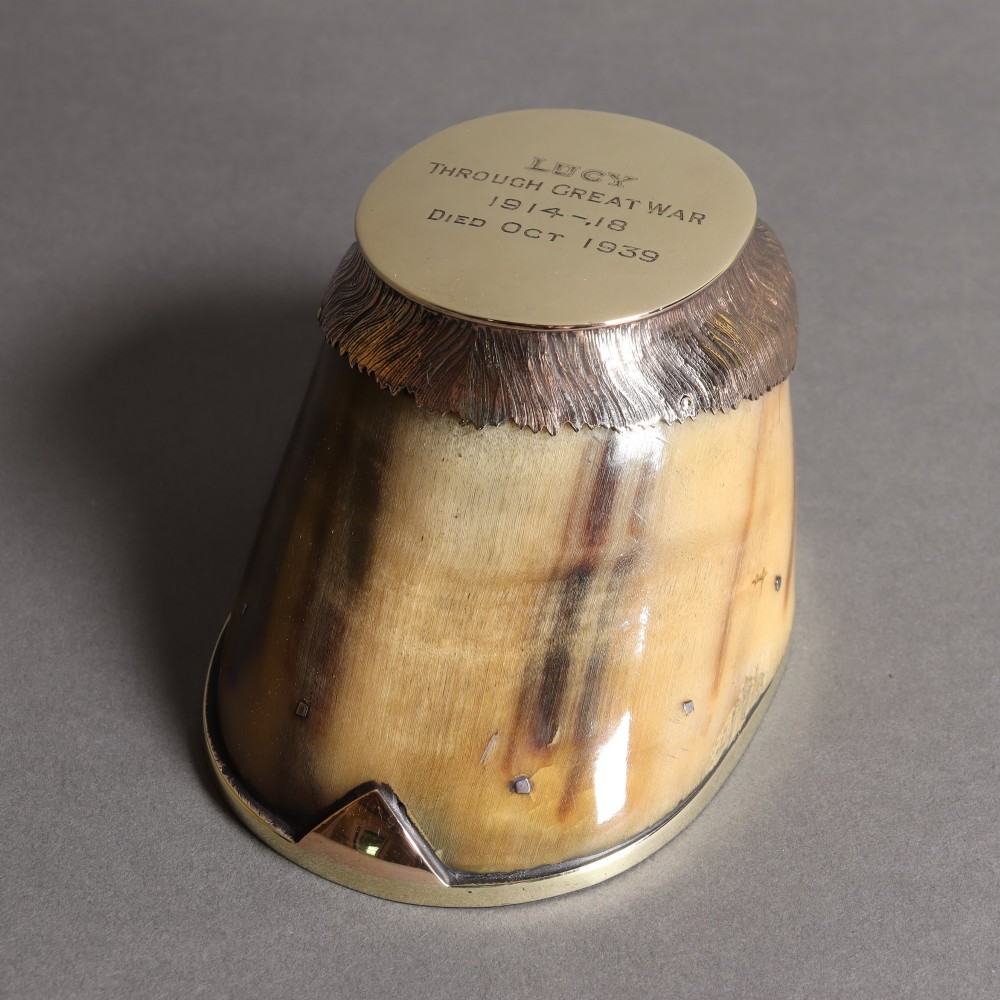 A preserved horse hoof mounted with an engraved brass top plate detailing military service dates and fitted with a polished brass rim around the base. View II